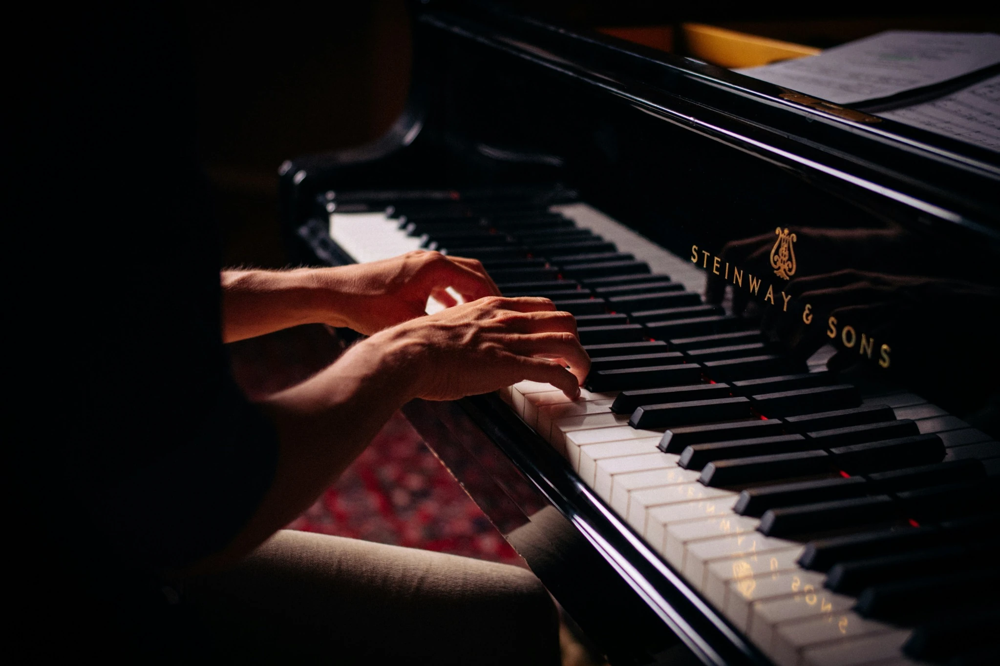 Manos de un pianista tocando en el aula